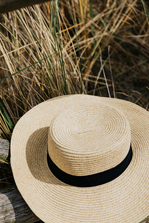a straw hat sitting on top of a wooden bench, by Nina Hamnett, trending on pexels, award - winning crisp details, sunlit sky, lush surroundings, a round minimalist behind
