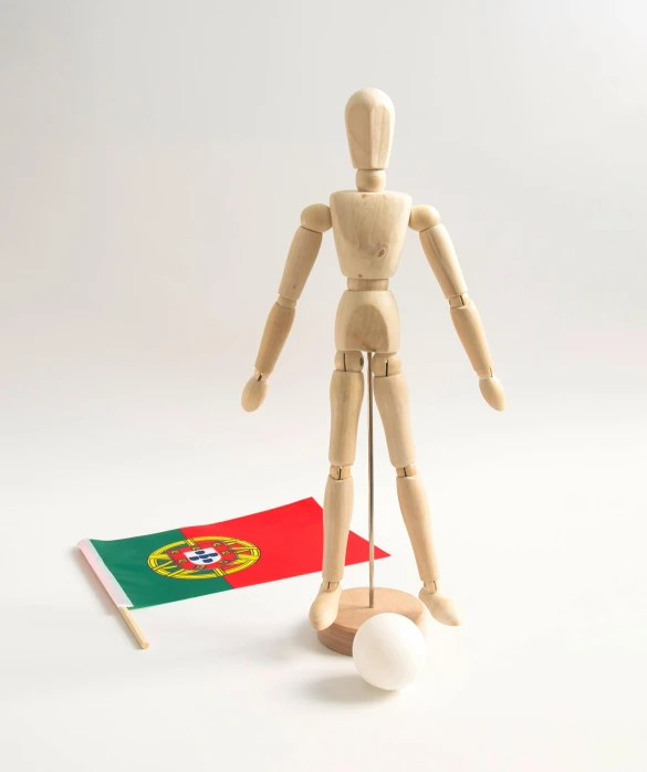 a wooden mannequin standing next to a portugal flag, by John Henderson, process art, fully posable, 1 figure only, art set, holding a pudica pose