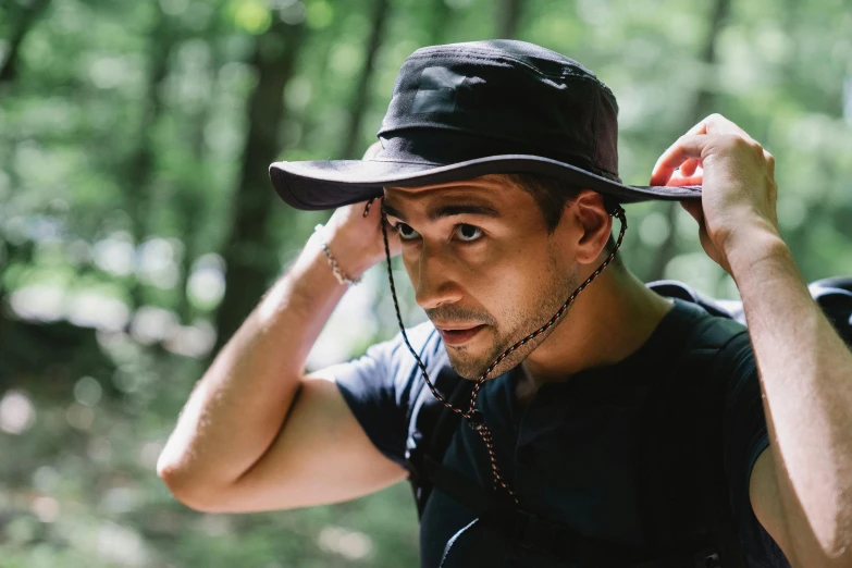 a man wearing a hat in the woods, official product photo, very sweaty, exploring, lightweight