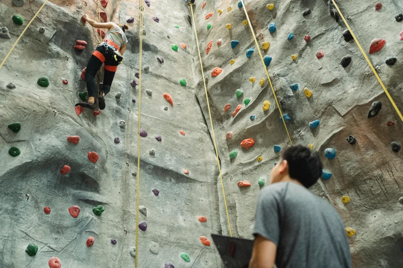 a man standing in front of a climbing wall, pexels contest winner, 🦩🪐🐞👩🏻🦳, teenager hangout spot, movie scene, local gym