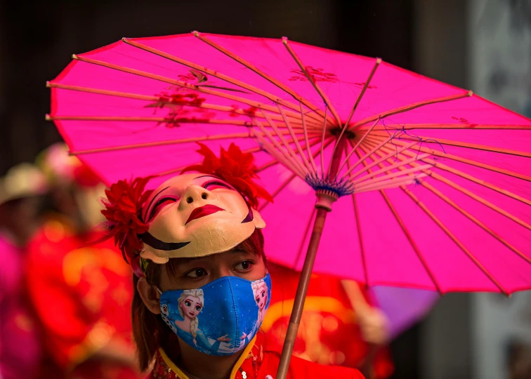 a woman wearing a mask and holding a pink umbrella, pexels contest winner, visual art, chinese ribbon dance, red face, thumbnail, f/1.4