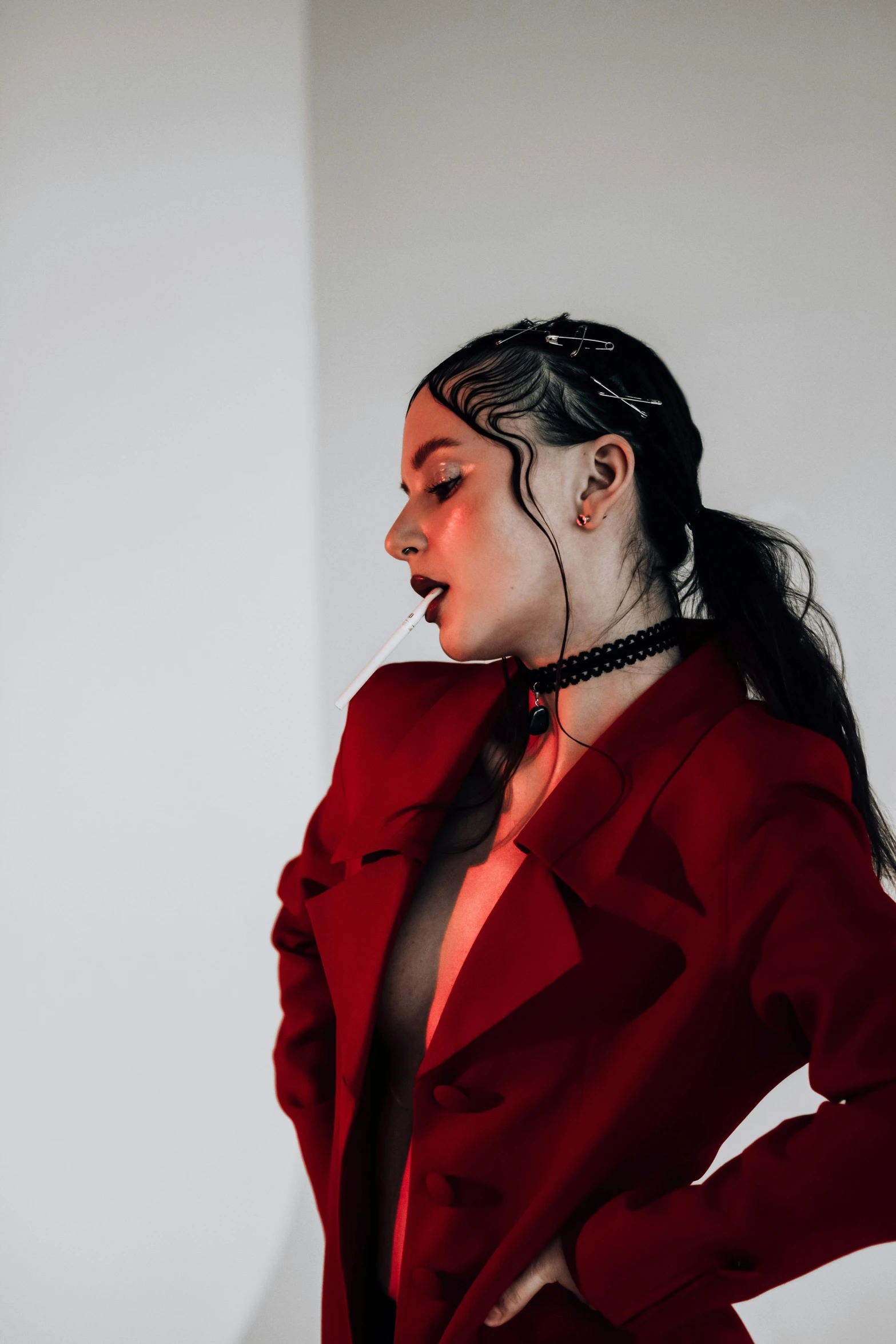 a woman in a red coat posing for a picture, an album cover, inspired by Elsa Bleda, trending on pexels, sasha grey, demon woman, profile image, wearing space techwear