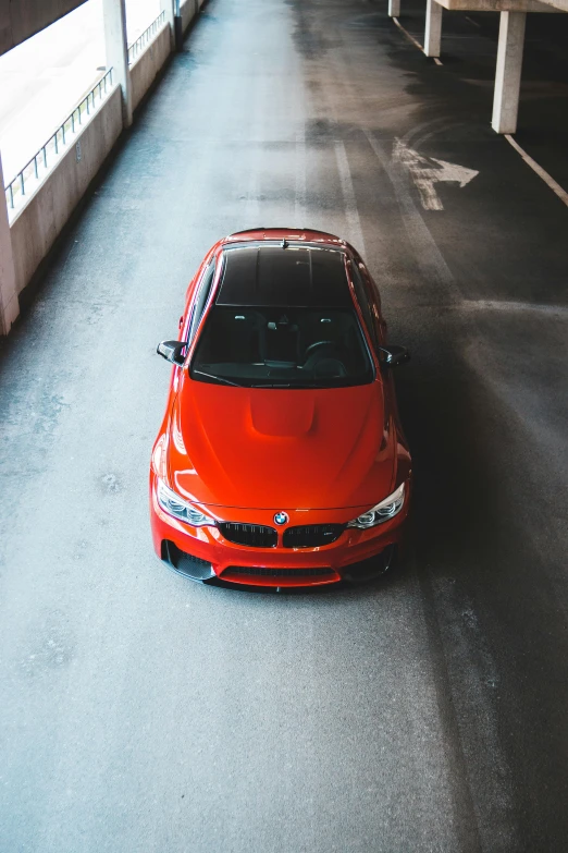 a red car parked in a parking garage, pexels contest winner, bmw m 1, drone shot, intense expression, thumbnail