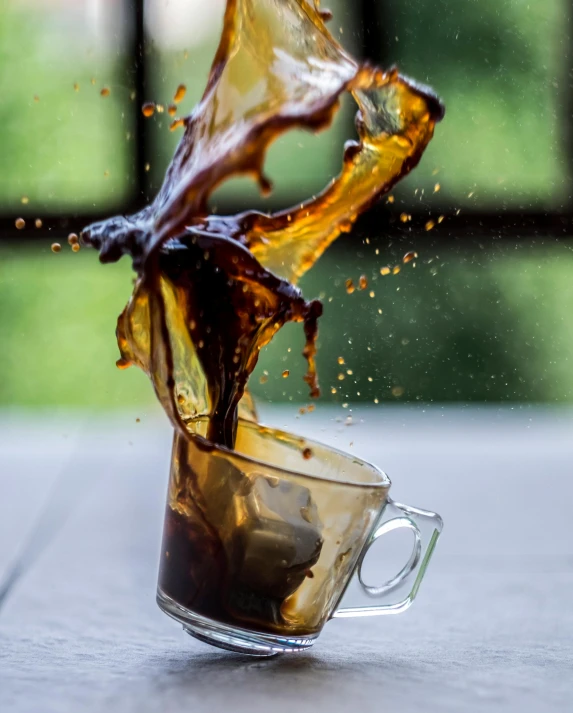 a cup filled with liquid sitting on top of a table, pexels contest winner, process art, leaping towards viewer, spilt coffee, promo image, shatter