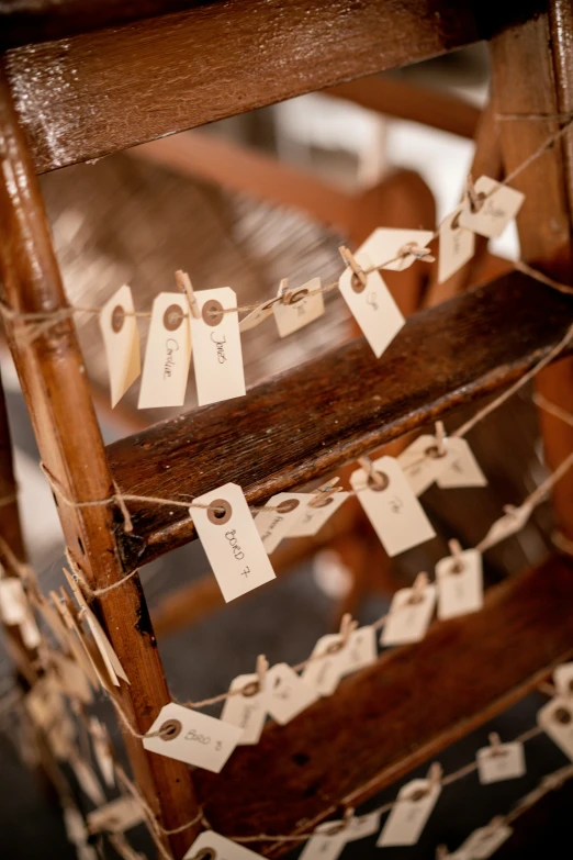 a close up of a wooden chair with tags on it, strings, multiple stories, d. i. y. venue, lots de details