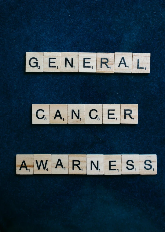 scrabbles spelling general cancer awareness on a blue background, a portrait, by Alison Geissler, pexels, on black background, a wooden, ca, military