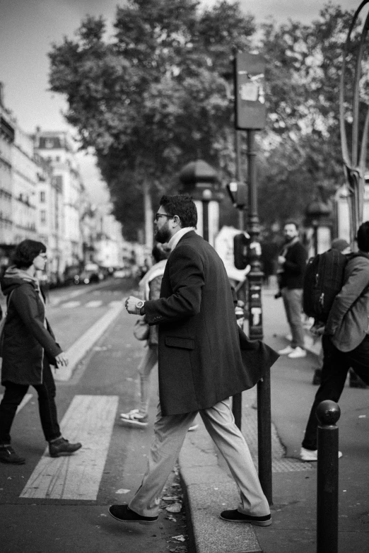 a black and white photo of people crossing the street, a black and white photo, by Pierre Mion, happening, tall man, looking at his phone, gentelman, paris
