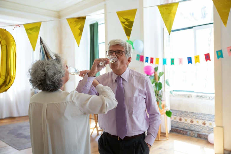 a man and a woman sharing a glass of wine, by Hazel Armour, pexels contest winner, wearing a party hat, old man doing with mask, pouring, at a birthday party