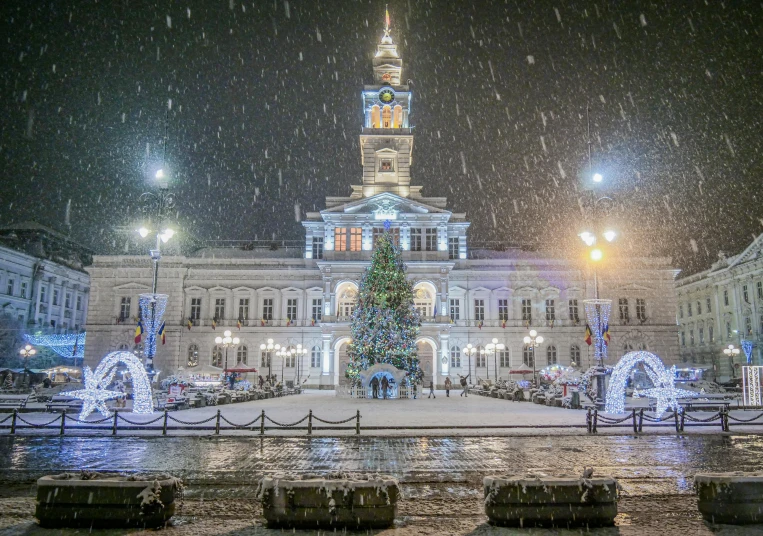 a large building with a christmas tree in front of it, by Giuseppe Avanzi, pexels contest winner, snowing outside, square, southern slav features, town hall