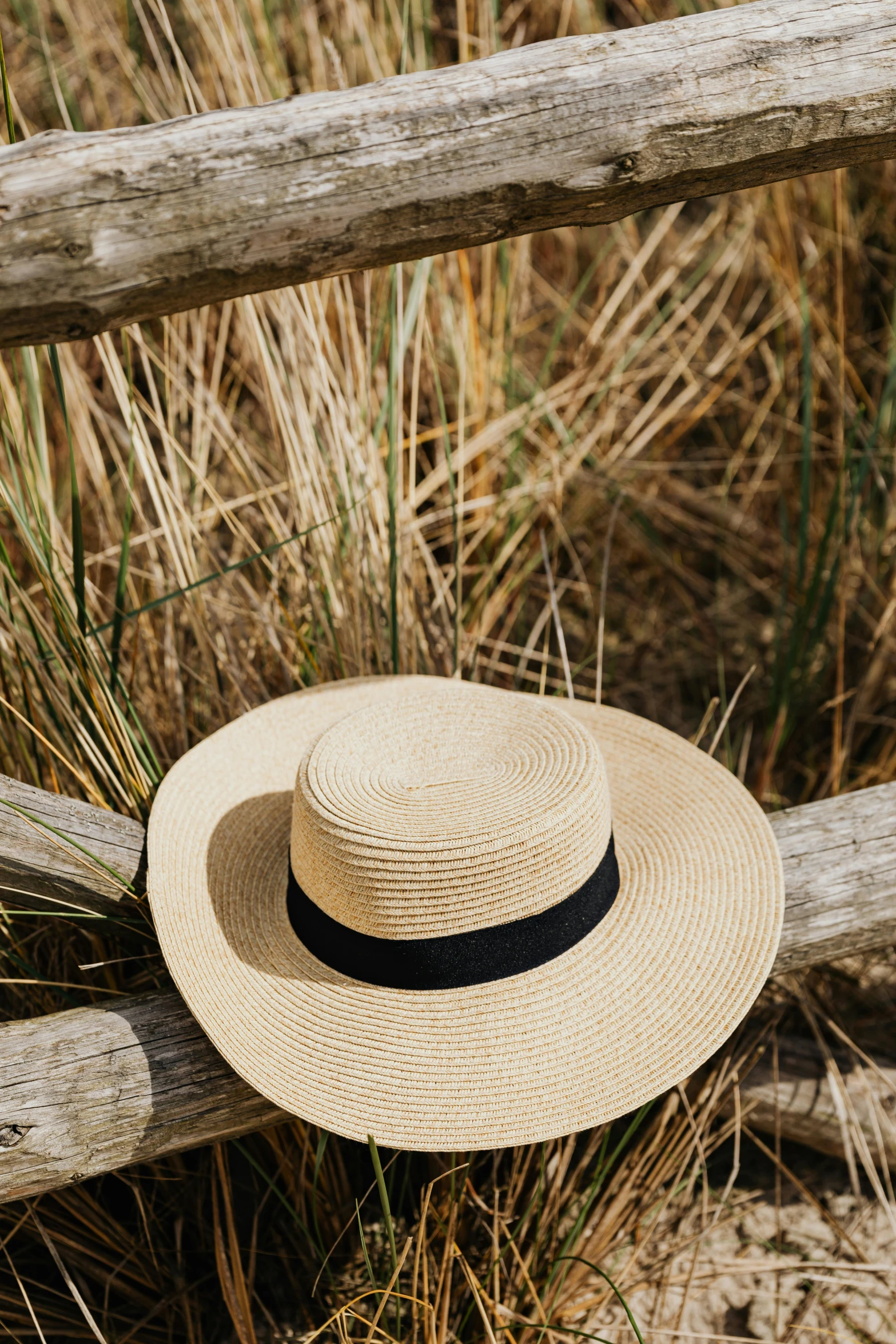 a straw hat sitting on top of a wooden fence, lush surroundings, curated collection, vanilla, round-cropped