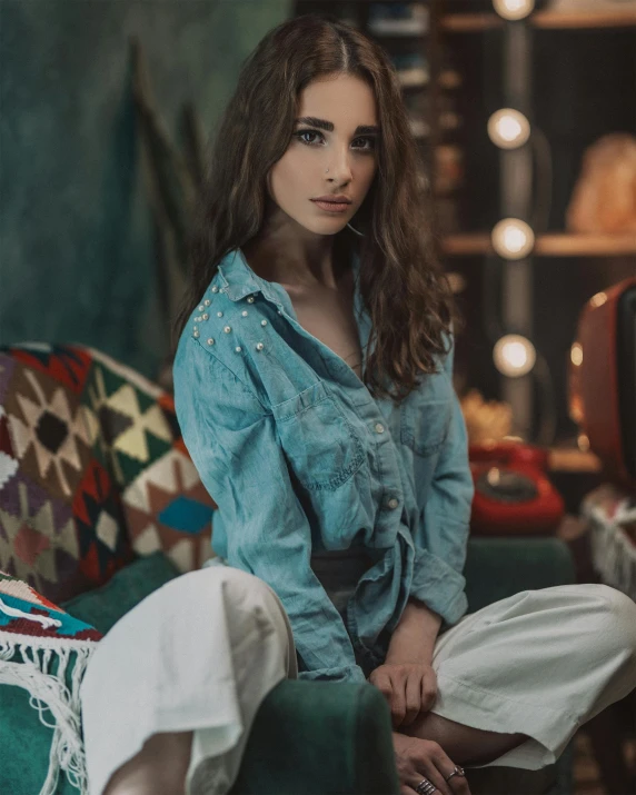 a beautiful young woman sitting on top of a green couch, inspired by Elsa Bleda, trending on pexels, photorealism, wearing double denim, lights on, outfit photo