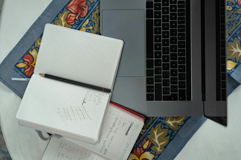 a laptop computer sitting on top of a table next to a notebook, by Carey Morris, grid arrangement, thumbnail, flat lay, multiple stories