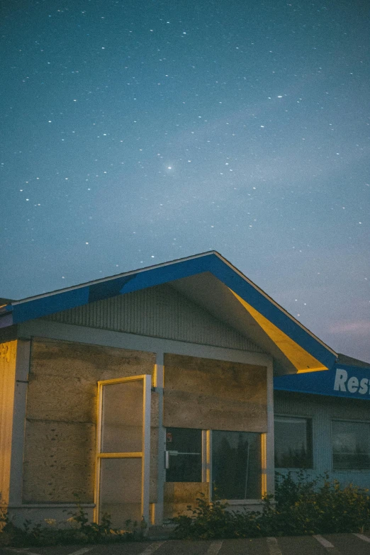 a building with a sky full of stars in the background, a picture, unsplash, renaissance, convenience store, restomod, resort, northern star at night