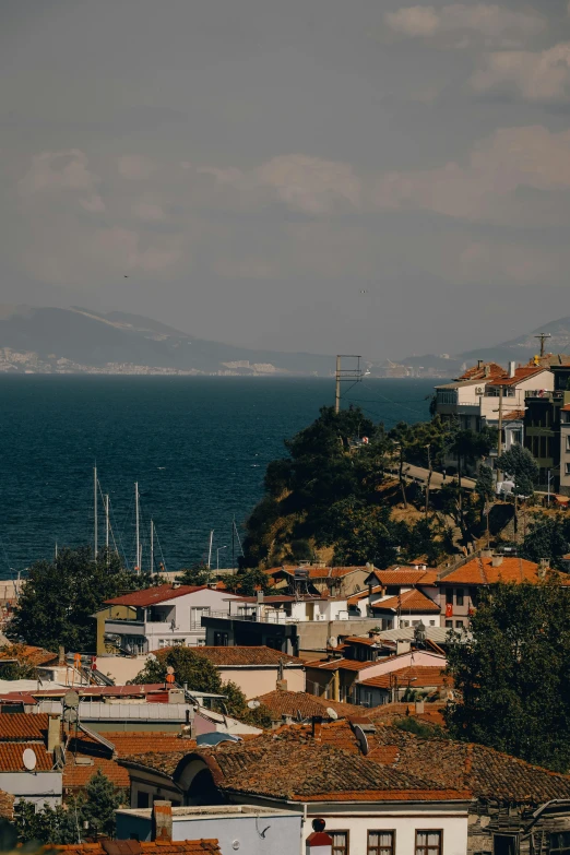 a group of buildings sitting on top of a hill next to the ocean, turkish and russian, high res 8k, multiple stories, photos