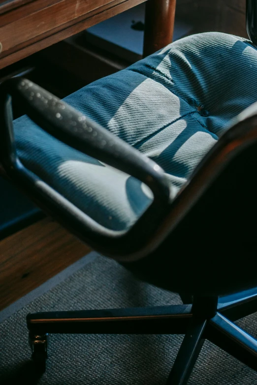 a chair that is sitting in front of a desk, inspired by Elsa Bleda, unsplash contest winner, worn out, high angle close up shot, blue and grey, late afternoon