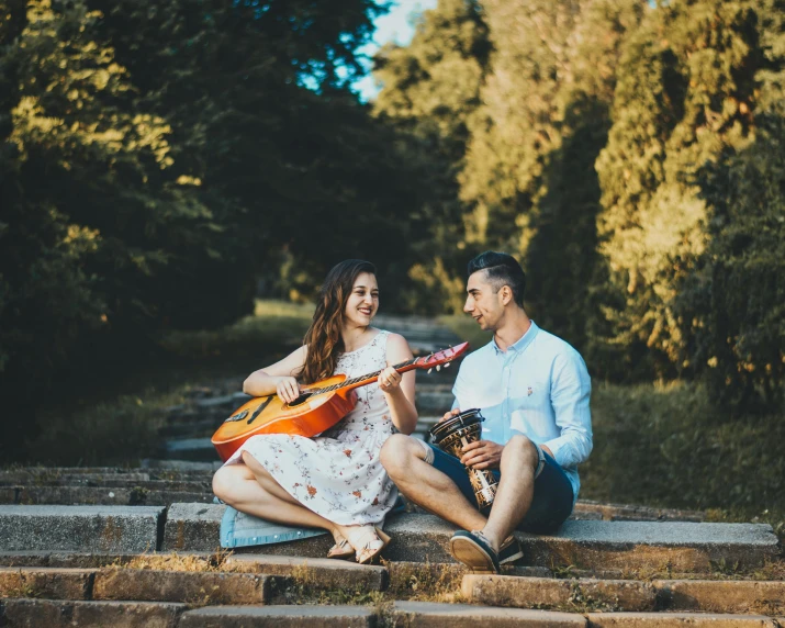 a man and woman sitting on steps playing guitar, pexels contest winner, in the park, avatar image, candid portrait photo, romanian