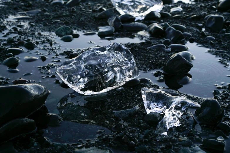 a pile of ice sitting on top of a rocky beach, an album cover, unsplash, hyperrealism, diamonds, black sand, thirst, ignant