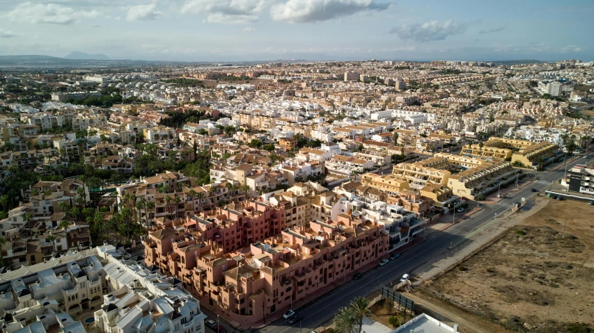 an aerial view of a city with lots of buildings, by Lee Loughridge, pexels contest winner, costa blanca, tan, jerez, apartment