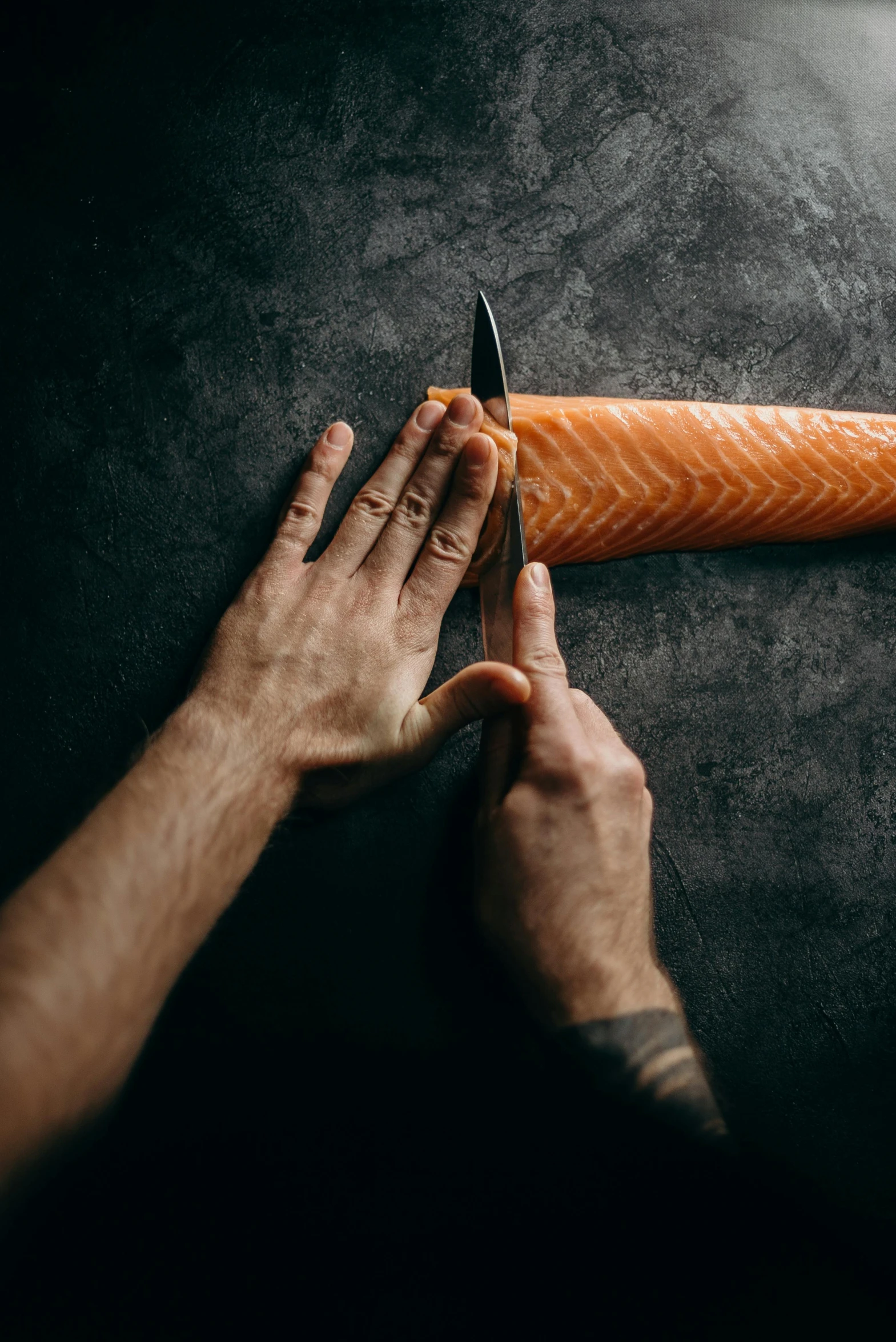 a person cutting a carrot with a knife, by Daarken, trending on pexels, fish skin, hands pressed together in bow, adam varga, male art