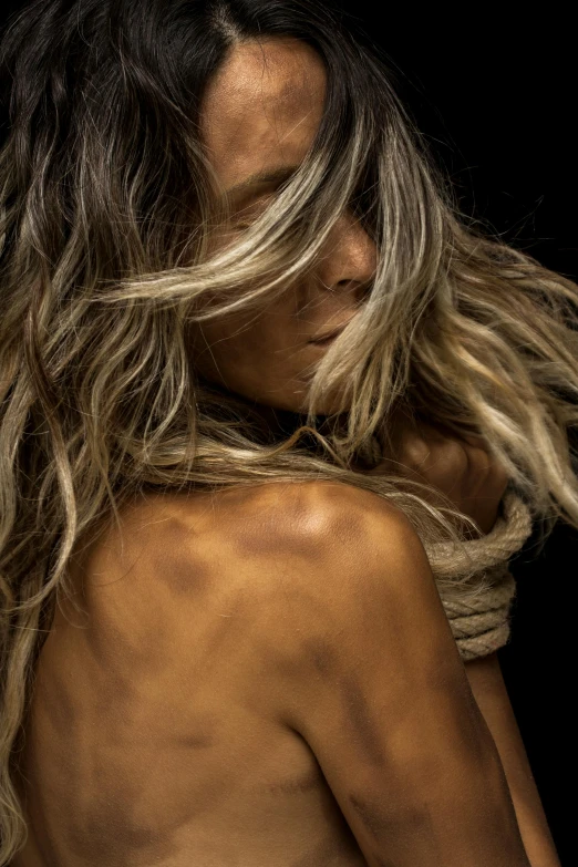 a naked woman standing in front of a black background, an album cover, by Bernat Sanjuan, trending on pexels, long ashy hair, ropes, caramel. rugged, balayage