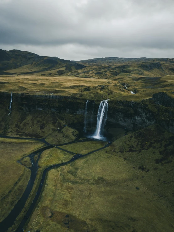 a waterfall in the middle of a green valley, by Johannes Voss, pexels contest winner, hurufiyya, wide high angle view, grey, festivals, less detailing