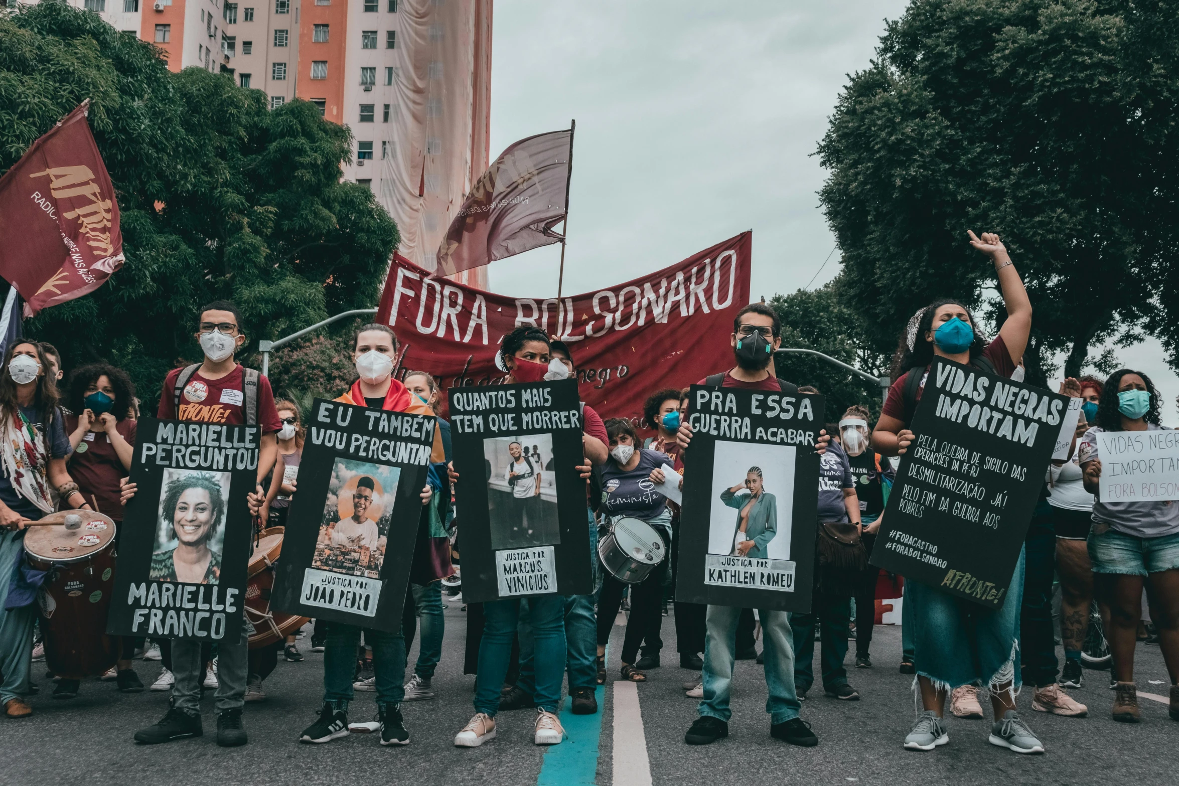 a group of people standing next to each other holding signs, a photo, by Amelia Peláez, pexels, antipodeans, in sao paulo, masqua, bulgari, walk in a funeral procession