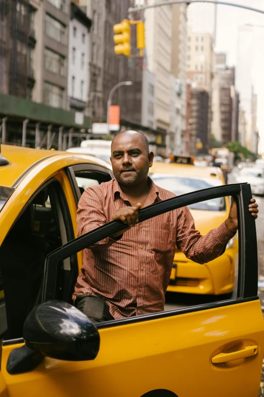 a man standing in the driver's seat of a taxi, happening, promo photo, jayison devadas, in new york city, square