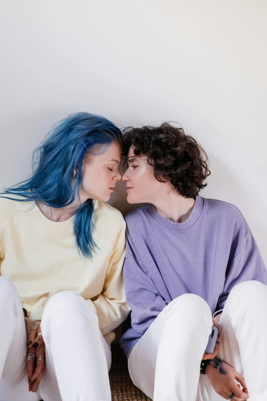 a couple of people sitting next to each other, trending on pexels, antipodeans, lesbian embrace, short blue hair, hana alisa omer, meredith schomburg