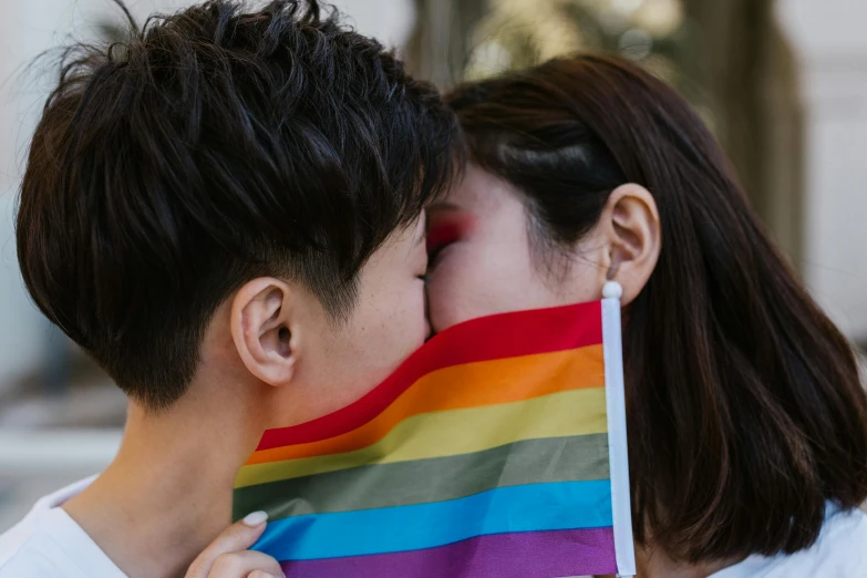 a couple kissing each other while holding a rainbow flag, trending on pexels, taiwan, 🚿🗝📝