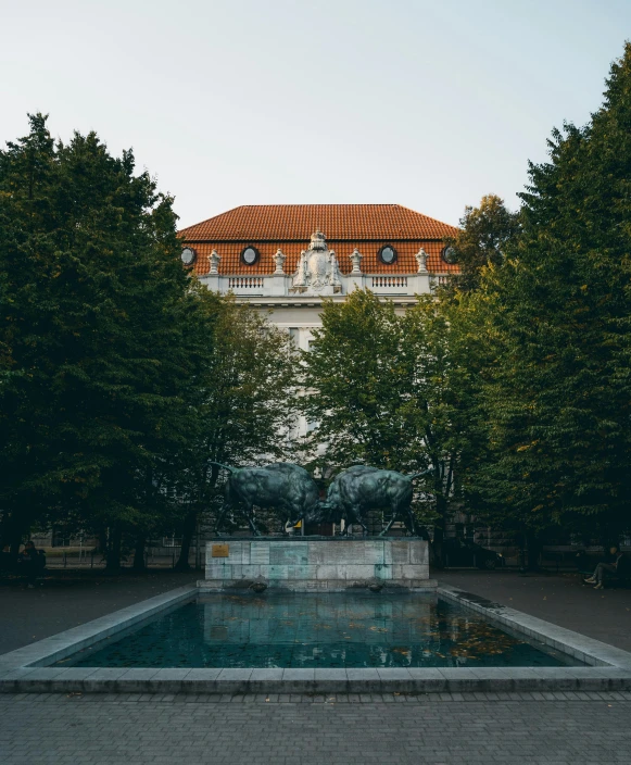 a large building with a fountain in front of it, by Emma Andijewska, unsplash contest winner, berlin secession, trees in background, squatting down next to a pool, thumbnail, austro - hungarian