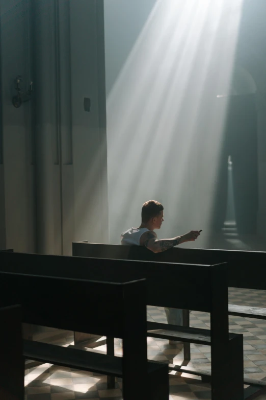 a person sitting on a bench in a church, pexels contest winner, light and space, light over boy, cinematic movie still, translucent, instagram picture
