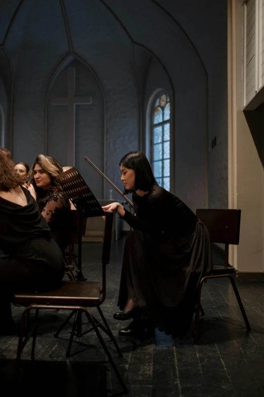 a group of women sitting next to each other in a room, an album cover, by Juriaen van Streeck, baroque, conductor, in a movie still cinematic, scene from church, [ theatrical ]