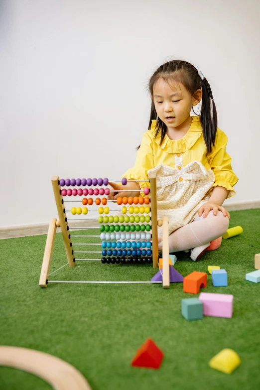 a little girl sitting on the floor playing with an abacuse, pexels contest winner, balancing the equation, educational supplies, square, park ji-min