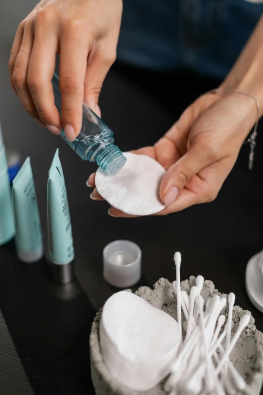 a close up of a person putting something in a container, a hyperrealistic painting, unsplash, plasticien, skincare, bottles covered in wax, photorealistic detail, porcelain