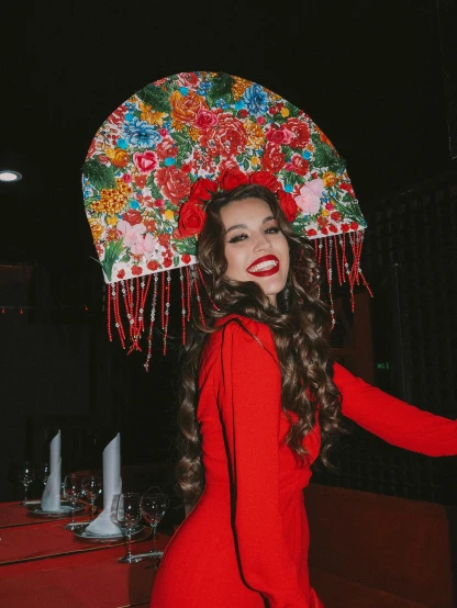 a woman in a red dress holding an umbrella, floral headpiece, instagram picture, bella poarch, wearing sombrero