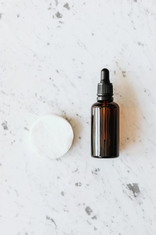 a bottle of essential oil sitting on top of a counter, unsplash, minimalism, white powder makeup, amber, thumbnail, round format