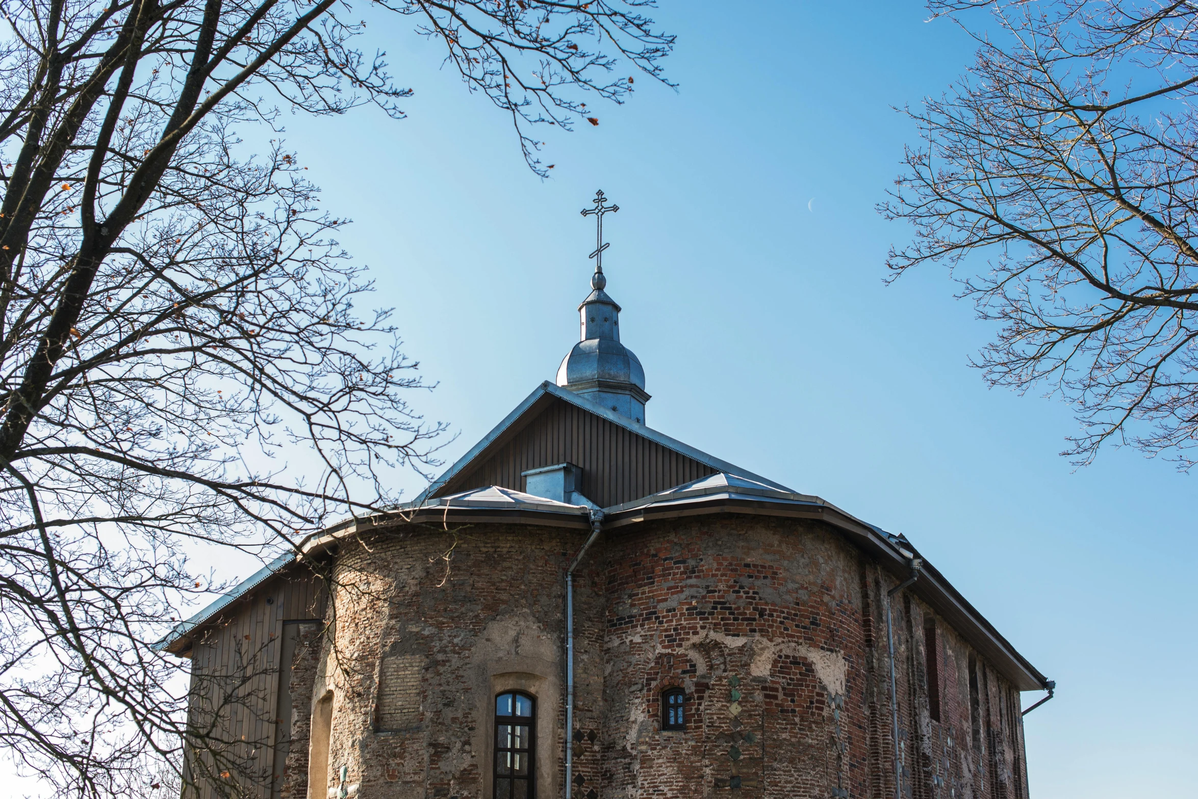 an old brick building with a steeple on top, a photo, by Maksimilijan Vanka, rounded roof, foil, kalevala, beautifully daylight