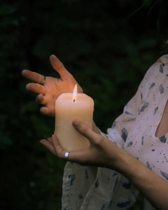 a woman holding a lit candle in her hands, inspired by Elsa Bleda, unsplash, outdoor photo, non-binary, resin, ilustration
