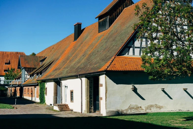 a couple of houses that are next to each other, a photo, by Werner Gutzeit, pexels contest winner, 1 8 8 0 s big german farmhouse, orange roof, alvar aalto, exterior view