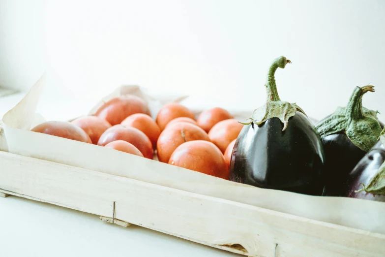 a close up of a tray of fruit and vegetables, a still life, unsplash, background image, eggplant, product shot, tilt and orange