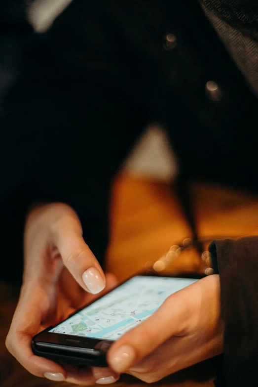a close up of a person holding a cell phone, by Niko Henrichon, trending on pexels, happening, cartographic, on a table, 6 : 3 0 am, subtle