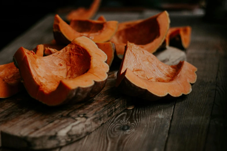 a wooden cutting board topped with cut up pumpkins, by Emma Andijewska, pexels, thumbnail, dark orange, profile pic, bark for skin