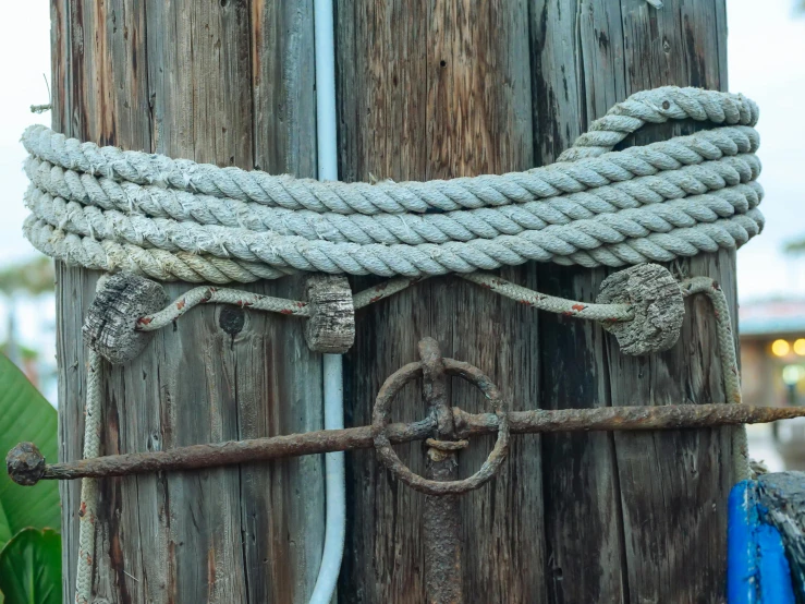 a close up of a rope on a wooden pole, an album cover, unsplash, renaissance, three masts, rusty components, low quality photo, 🦩🪐🐞👩🏻🦳