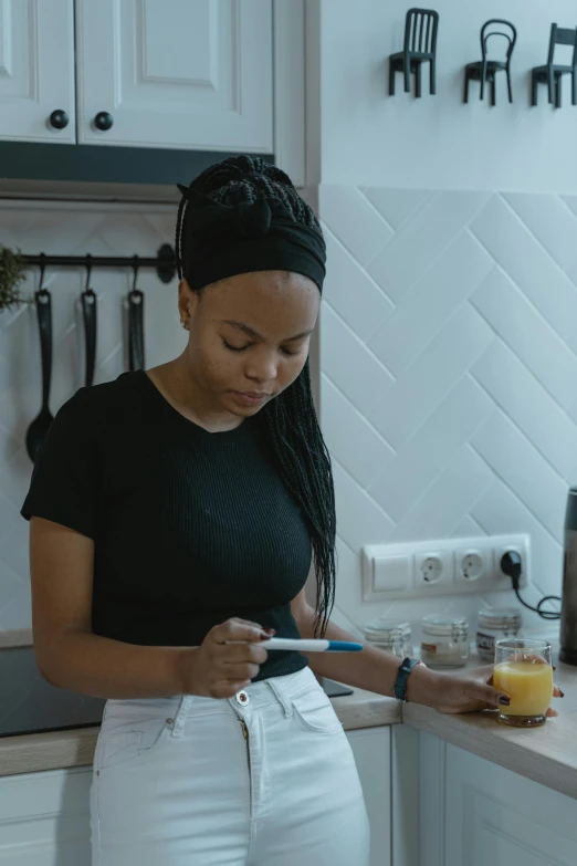 a woman standing in a kitchen looking at her phone, pexels contest winner, a teen black cyborg, low quality footage, trading card, healthcare worker