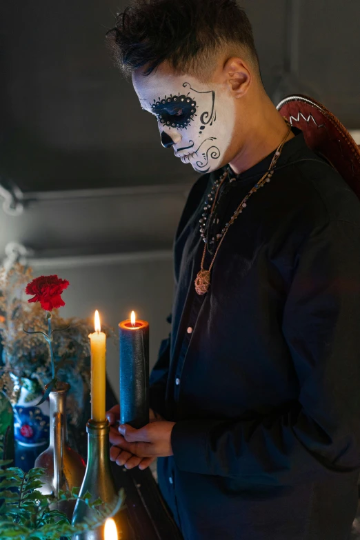 a person standing in front of a table with candles, sugar skull, a man wearing a black jacket, profile image, religious