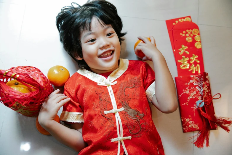 a little girl in a red dress holding an orange, inspired by Li Mei-shu, pexels contest winner, happening, earing a shirt laughing, cheongsam, little boy, square