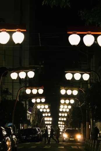 a city street filled with lots of traffic at night, inspired by Kanō Naizen, unsplash, sōsaku hanga, hanging lanterns, symmetric lights, close - up photo, square