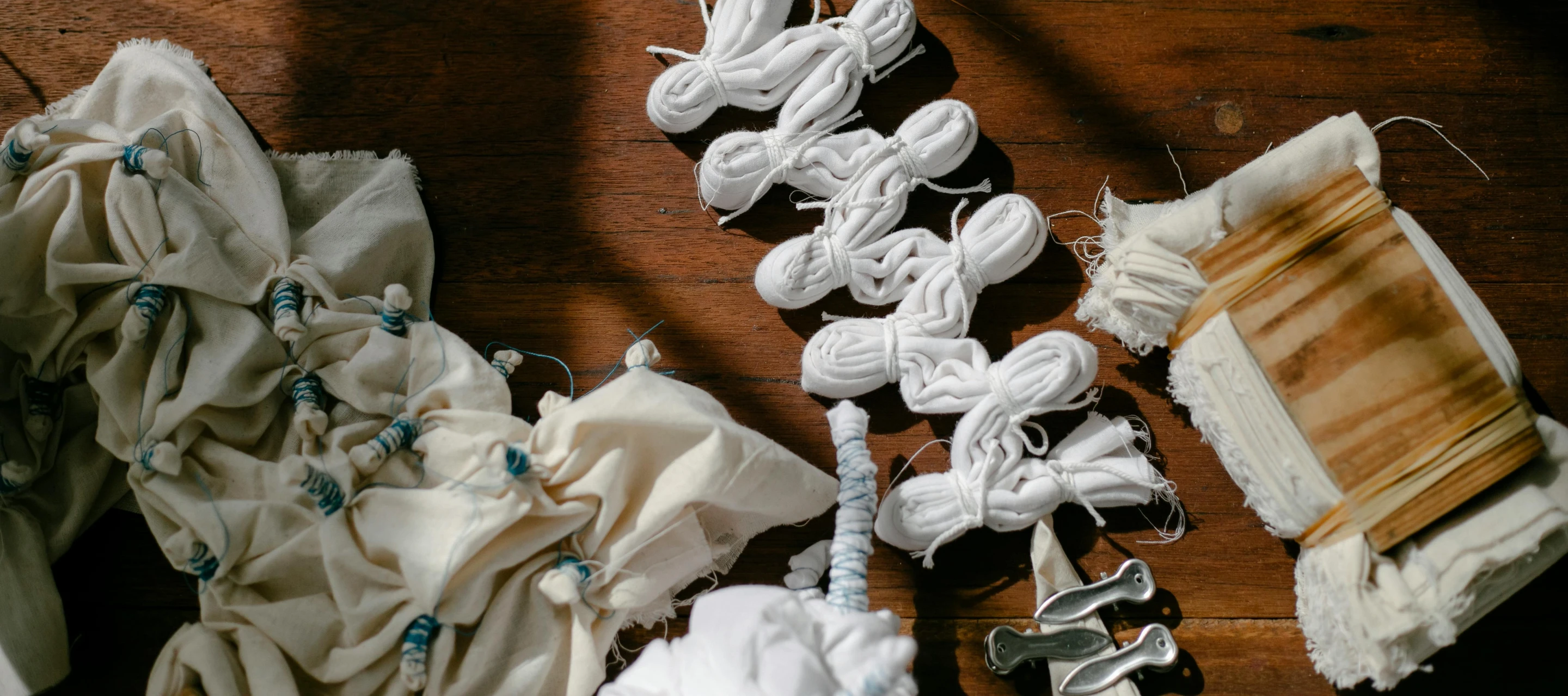 a pile of cloth sitting on top of a wooden floor, inspired by Sarah Lucas, unsplash, process art, twintails white_gloves, with wires and bandages, puff sleeves, white mechanical details