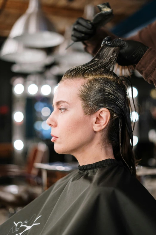 a woman getting her hair done in a salon, slicked-back hair, press shot, oil slick, on location