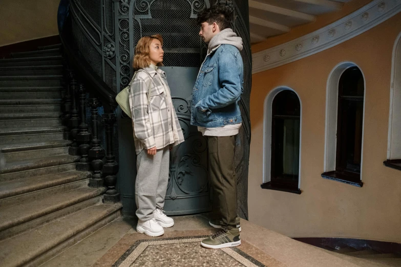 a man and a woman standing in front of a staircase, by Grytė Pintukaitė, pexels contest winner, hyperrealism, wearing cargo pants, still image from tv series, teenage girl, scene from church